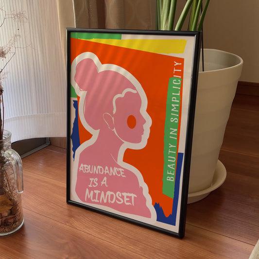 Framed poster with a silhouette of a woman and motivational quote on a wooden surface with decorative elements.